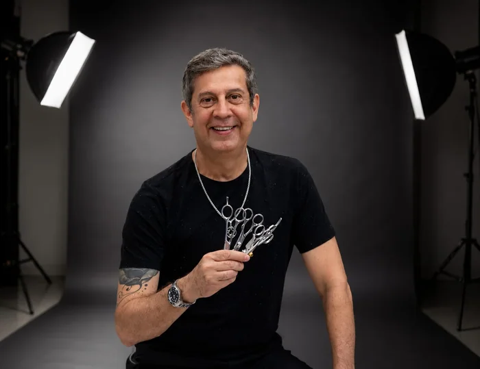 Edu Domingos em estúdio fotográfico, com as tesouras na mão